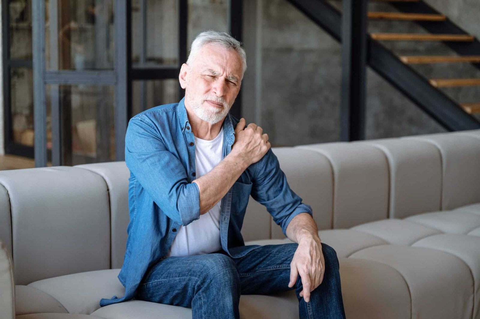 Person hält sich den schmerzenden Rücken - Symbolbild für Schmerzwahrnehmung