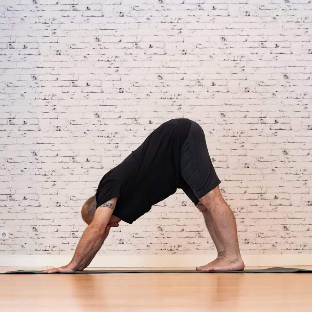 Körperhaltung verbessern: Tipps gegen Rückenschmerzen 27 Schmerzfreiheit, Beweglichkeit, Kraft: Körperhaltung verbessern - Ein Mann der die downward looking dog position ausführt
