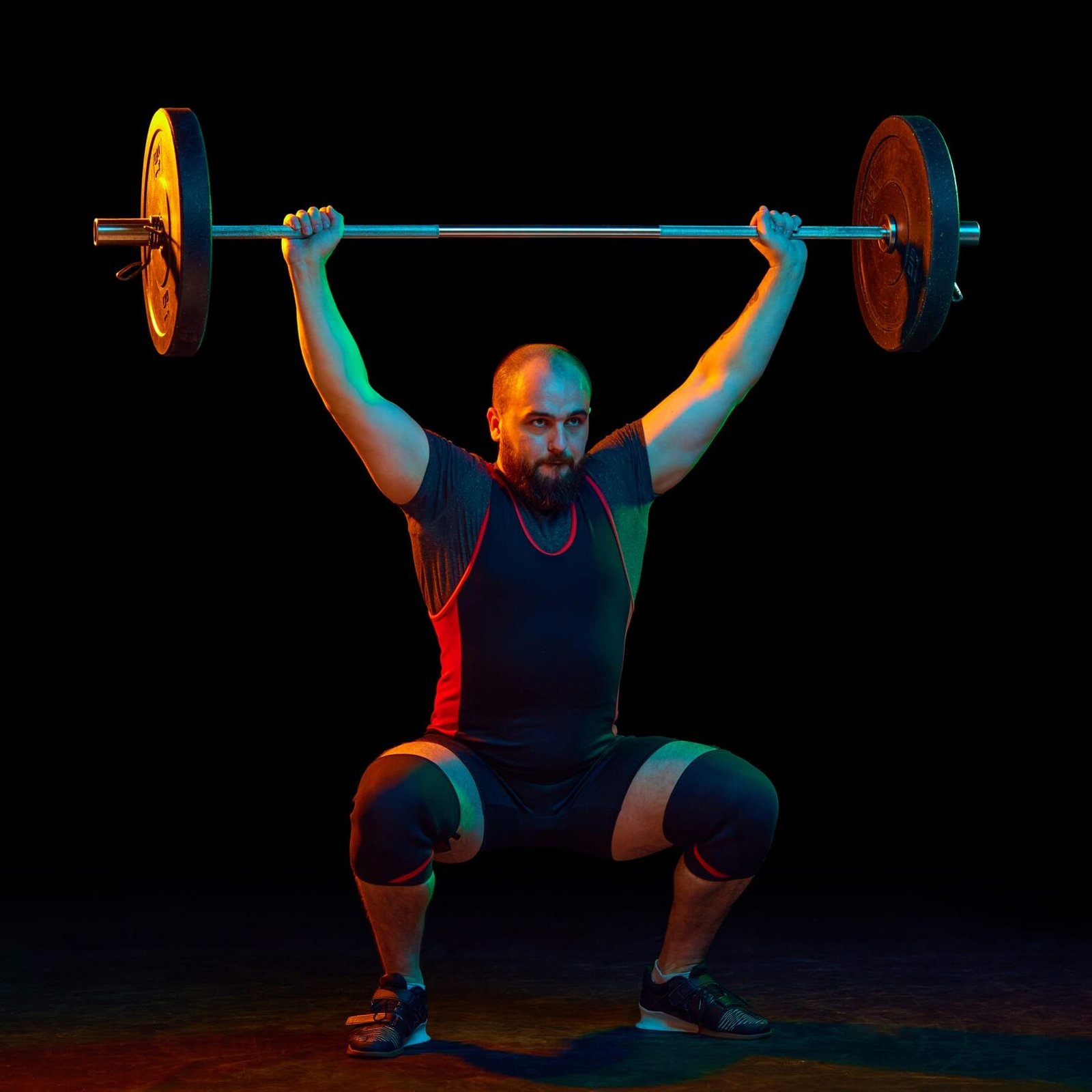 Gewichtheber in tiefer Kniebeuge mit Langhantel