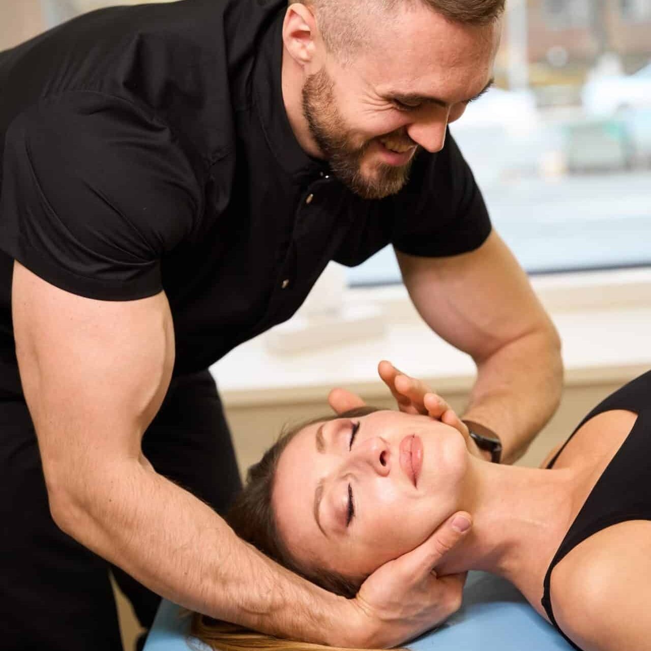 Chiropraktiker behandelt Patientin an der Halswirbelsäule