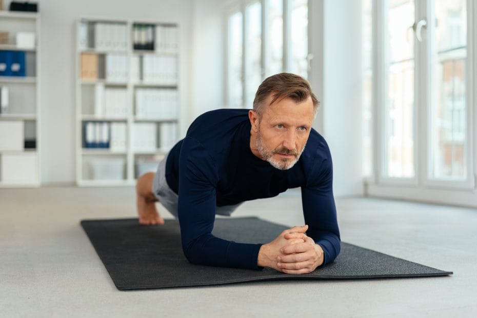 Athletischer Mann macht Plankenübungen in einem Fitnessstudio