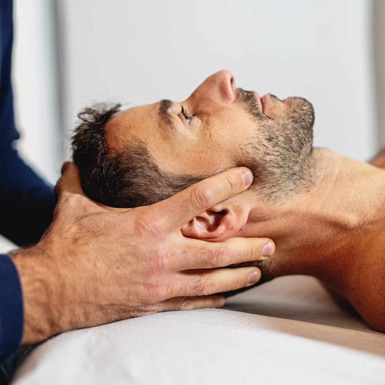 Physiotherapeutin behandelt einen Patienten mit Rückenschmerzen