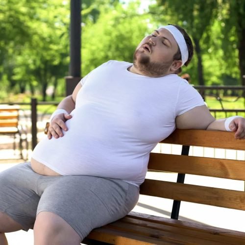 Ernährungsberatung - Gewichtsreduktion - Rückenschmerzen - abnehmen für Menschen mit Schmerzen - Obese man feels side aches after intense workouts outdoors, health problems